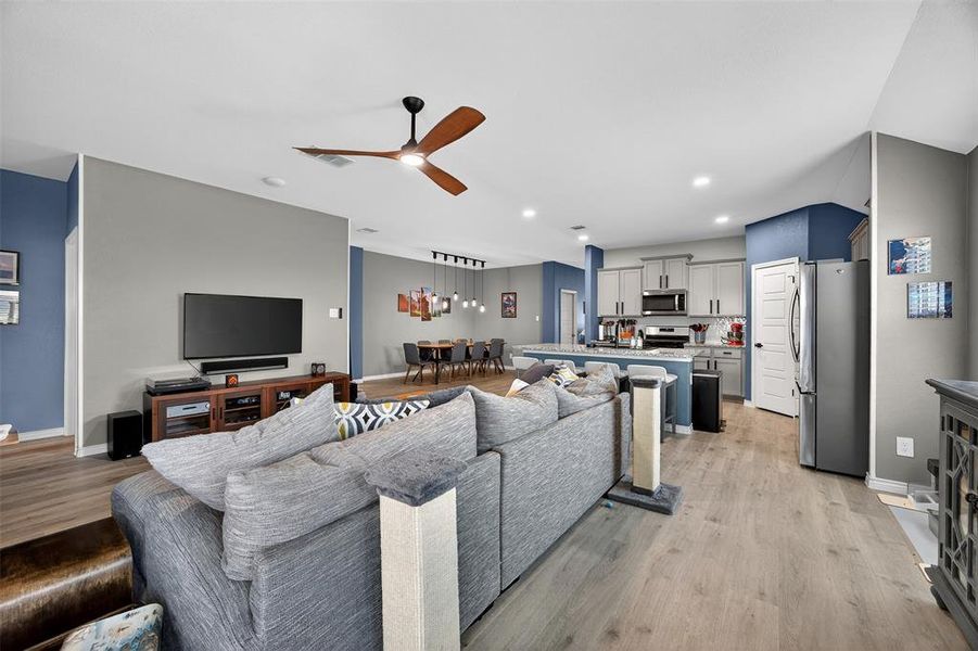Living area featuring ceiling fan, light wood finished floors, and recessed lighting
