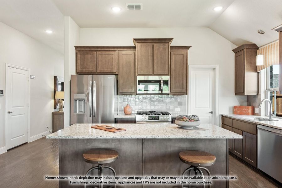 Kitchen with dark wood cabinets, granite island with two stools, and stainless steel appliances Kitchen with dark wood cabinets, granite island with two stools, and stainless steel appliances