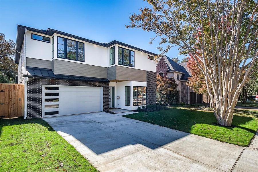 View of front of home with a garage and a front lawn