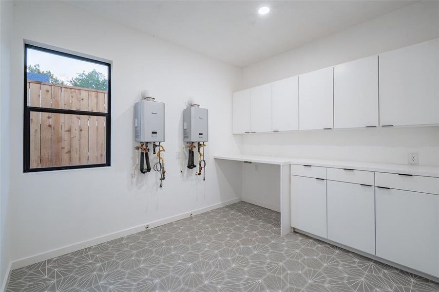 Washroom featuring water heater and light tile patterned floors