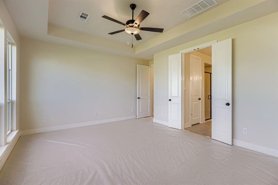 Spare room with a tray ceiling and a ceiling fan