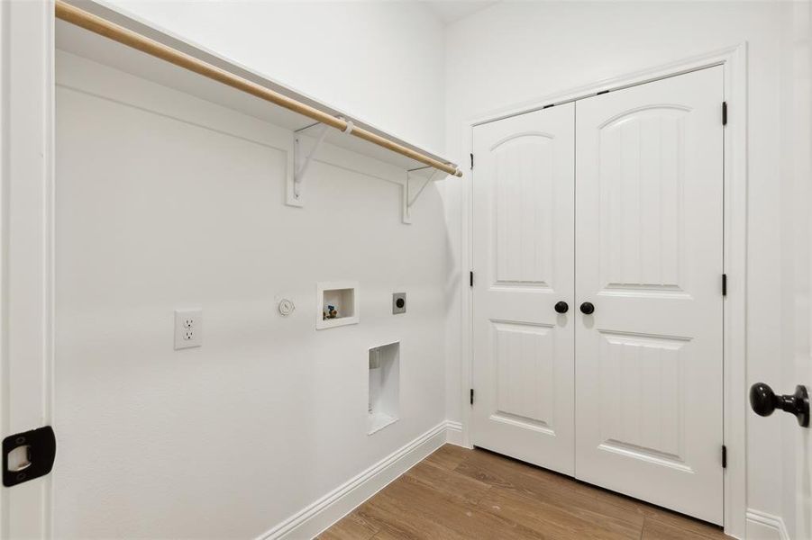 Washroom featuring light hardwood / wood-style flooring, electric dryer hookup, hookup for a gas dryer, and washer hookup