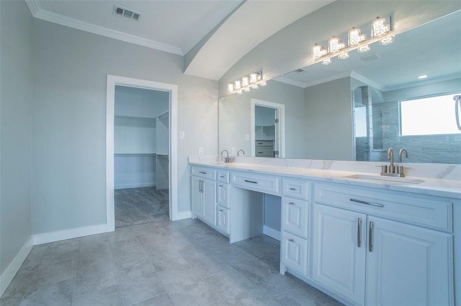 Full bathroom featuring crown molding, a spacious closet, double vanity, and walk in shower Full bathroom featuring crown molding, a spacious closet, double vanity, and walk in shower