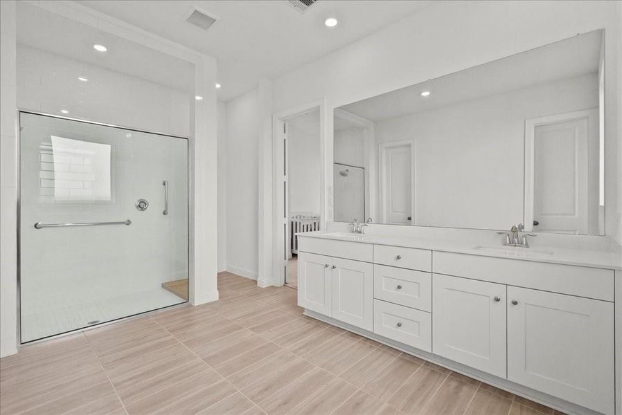 Spa-like en-suite bath with an oversized walk-in shower, double sinks, and a generous walk-in closet. Spa-like en-suite bath with an oversized walk-in shower, double sinks, and a generous walk-in closet.