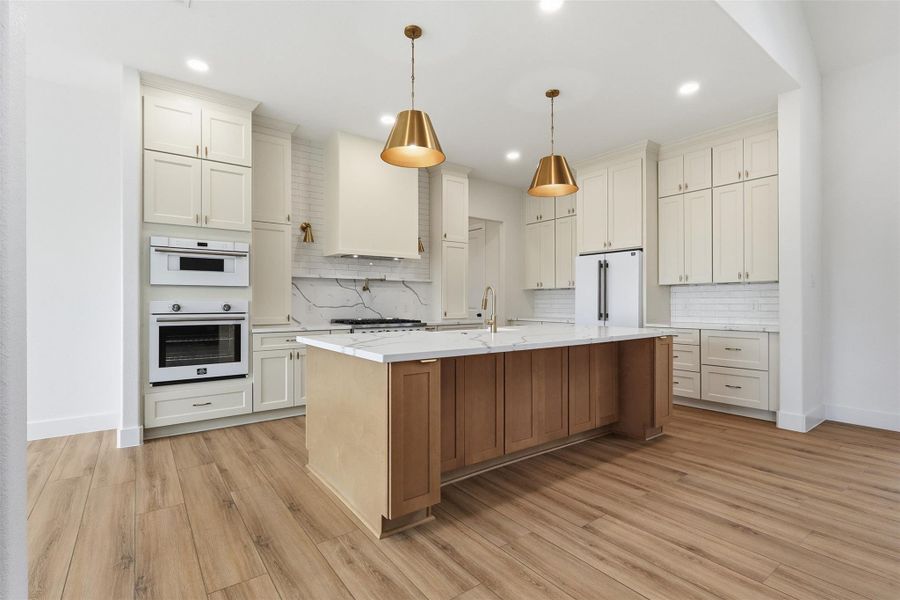 Stunning kitchen with designer finishes. Photos are of prior LOTUS plan homesite built by Aurcova. Stunning kitchen with designer finishes. Photos are of prior LOTUS plan homesite built by Aurcova.