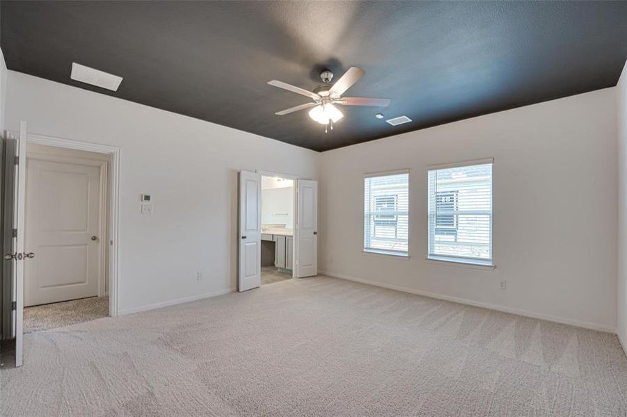 Carpeted empty room featuring ceiling fan