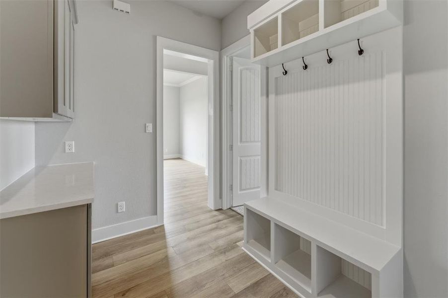 Mudroom with light wood-style flooring and baseboards