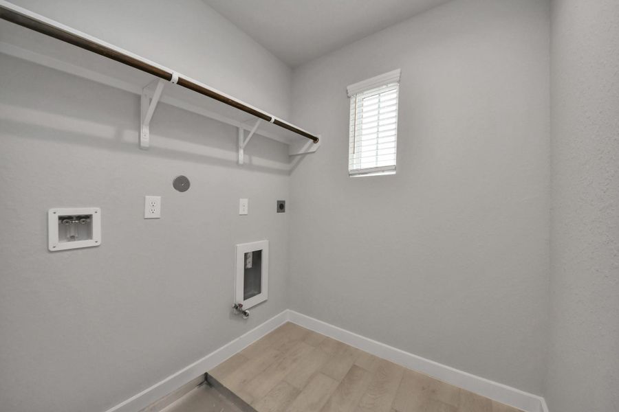 A perfect blend of functionality and comfort. Capture the essence of easy living with a first-floor laundry room, thoughtfully equipped with shelving for effortless organization. Bothelectric and gas connections available. Sample photo of completed home with similar floor plan. Actual colors and selections may vary. A perfect blend of functionality and comfort. Capture the essence of easy living with a first-floor laundry room, thoughtfully equipped with shelving for effortless organization. Bothelectric and gas connections available. Sample photo of completed home with similar floor plan. Actual colors and selections may vary.