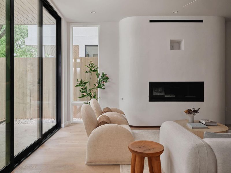 Living area featuring a modern fireplace with a curved white surround and an integrated niche
