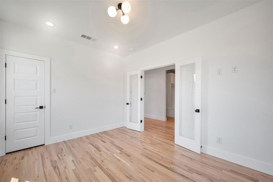Unfurnished room featuring recessed lighting, light wood-style flooring, and french doors