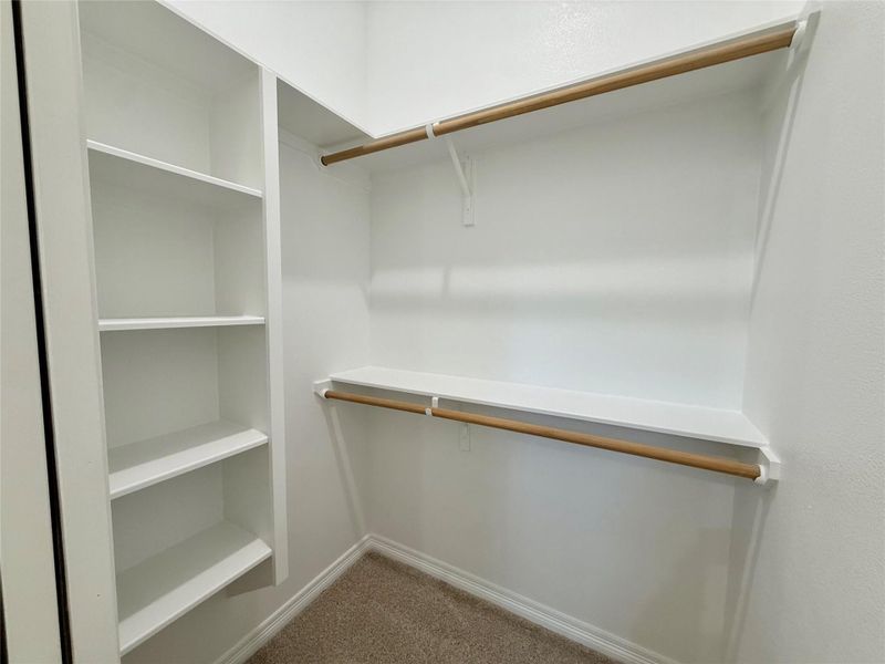 Walk in closet with dark carpet