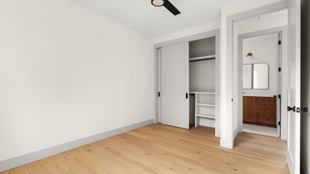 Unfurnished bedroom featuring light wood-style floors, a closet, and a ceiling fan