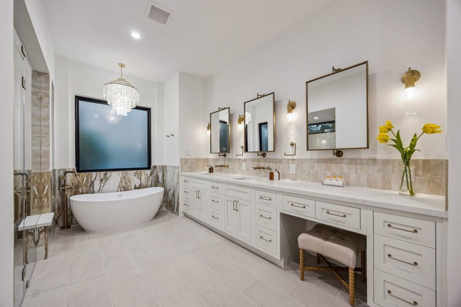 Primary Bath with 12 x 24 Matt Tile Floor. Inset Shaker Style Cabinetry with Soft Close Drawers and Doors. Long Double Vanity with Slab Quartz Counter and a 2 x 6 Glossy Tile Backsplash. Dual Rectangle Sinks, Dual Widespread Wall-Mounted Faucets in a Luxe Gold Finish, Three Pivot Mirrors with Champagne Gold Finish, Four 1 Light, 16" High LED Wall Sconces in a Gold Finish. There is also a knee space and Seperate Commode Area.