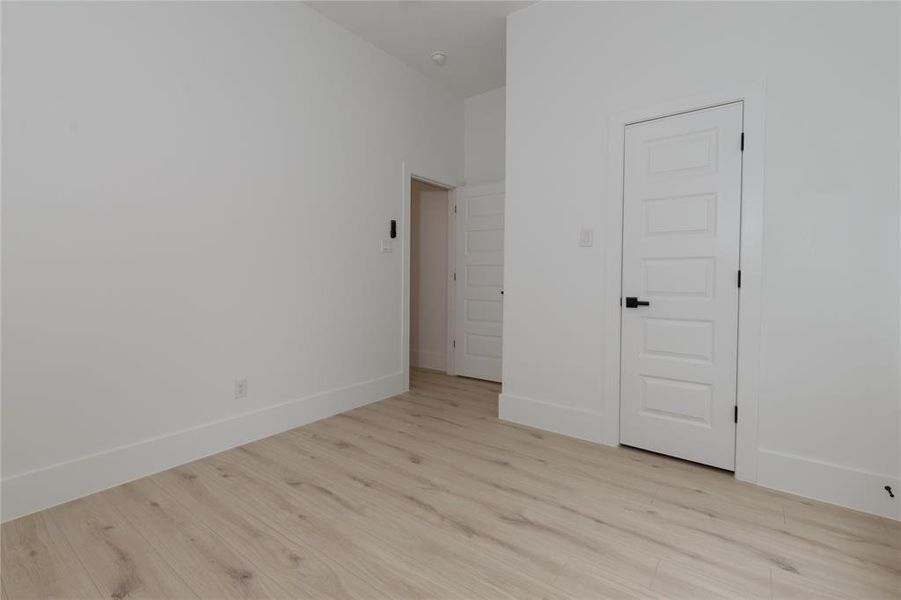 Unfurnished bedroom featuring light wood finished floors and a closet