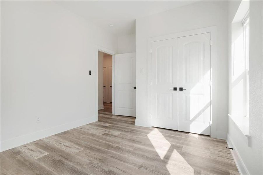 Bedroom 3 with wood-style floors and a closet