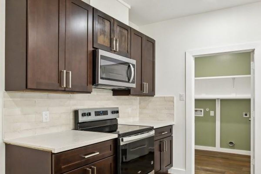 Elegant kitchen featuring sleek cabinetry, modern appliances, and luxurious quartz countertops. Elegant kitchen featuring sleek cabinetry, modern appliances, and luxurious quartz countertops.