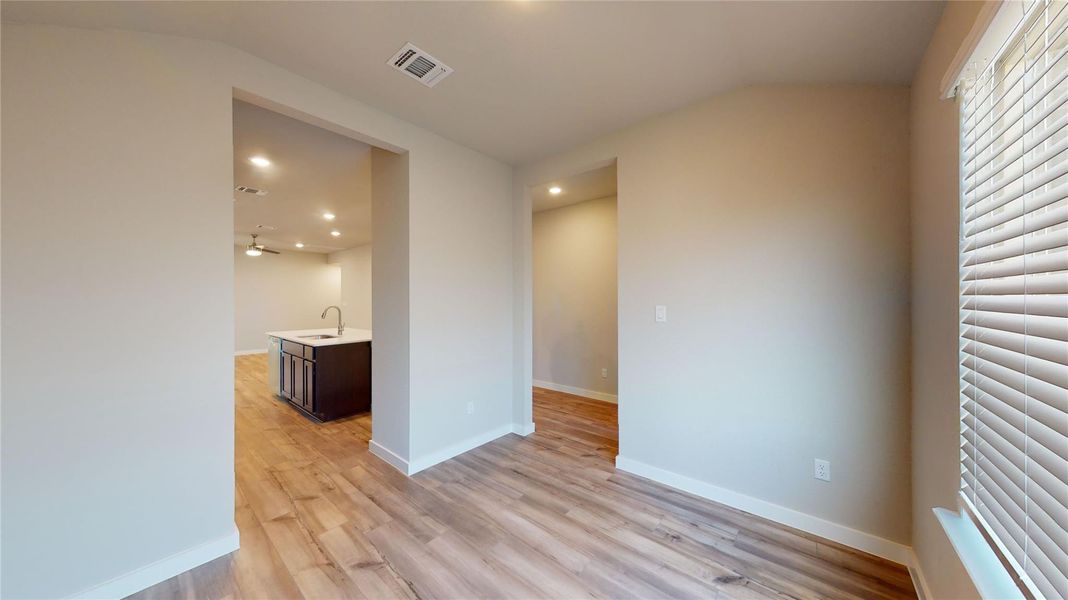 Hardwood floors flow through an open-concept living space with ample recessed lighting. Hardwood floors flow through an open-concept living space with ample recessed lighting.