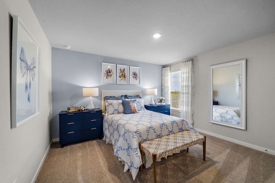 A bedroom with a bed and a bench.