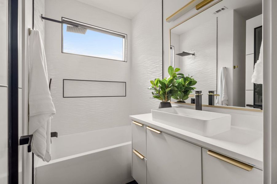 A sleek vanity with an integrated sink and modern fixtures enhances this pristine bathroom. A sleek vanity with an integrated sink and modern fixtures enhances this pristine bathroom.