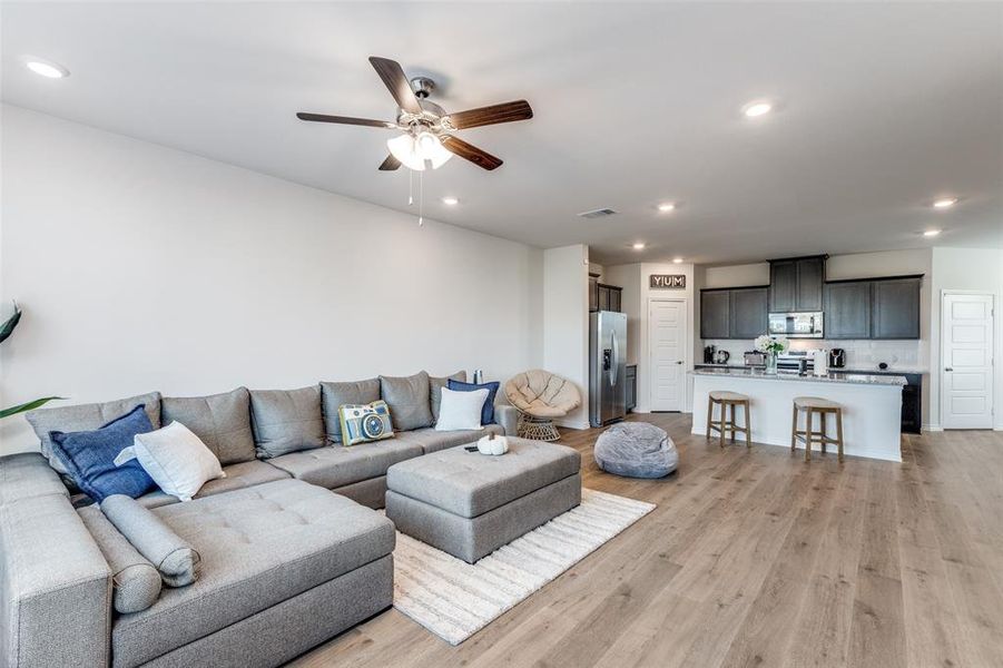 Living room with recessed lighting, light wood finished floors, and ceiling fan Living room with recessed lighting, light wood finished floors, and ceiling fan