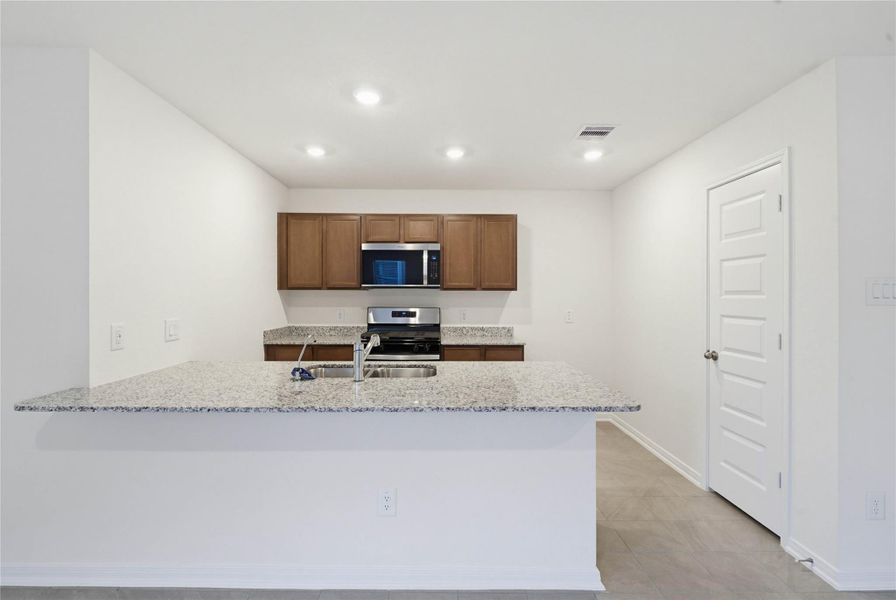 This spacious kitchen has it all—ample storage, generous counter space, and a layout that truly makes it the heart of the home.