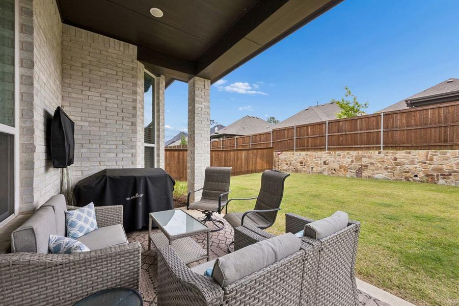 Covered patio featuring a light brick exterior and a dark soffit ceiling