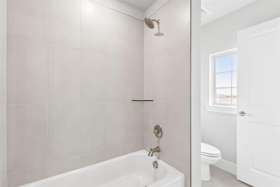 Bathroom featuring shower / bath combination and tile patterned flooring Bathroom featuring shower / bath combination and tile patterned flooring