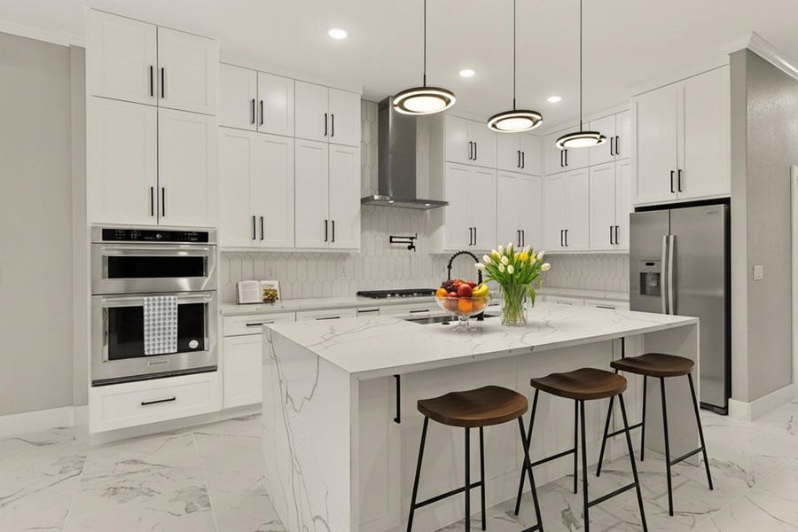 Kitchen featuring island with quartz countertops, a kitchen breakfast bar, wall chimney exhaust hood, pot filler faucet, Refrigerator is virtually staged Kitchen featuring island with quartz countertops, a kitchen breakfast bar, wall chimney exhaust hood, pot filler faucet, Refrigerator is virtually staged