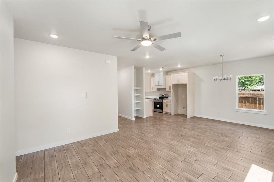 Open-concept living area featuring wood-look tile flooring, recessed lighting, and a contemporary ceiling fan Open-concept living area featuring wood-look tile flooring, recessed lighting, and a contemporary ceiling fan