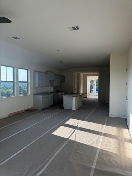 Unfurnished living room featuring baseboards and a sink Unfurnished living room featuring baseboards and a sink
