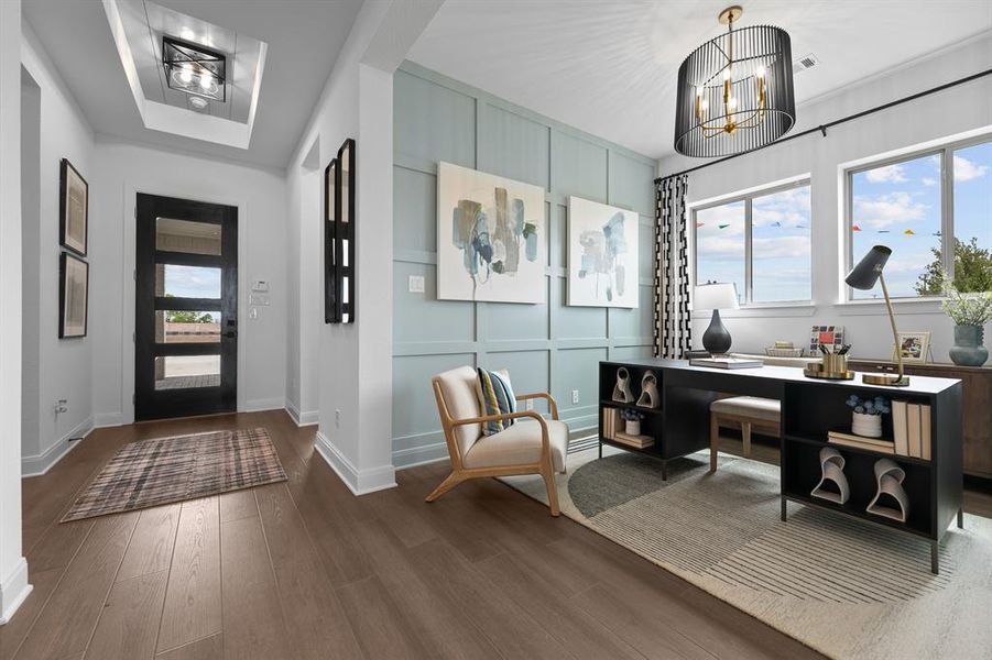 Entryway featuring suspended lighting, a decorative wall, and dark wood-style floors Entryway featuring suspended lighting, a decorative wall, and dark wood-style floors
