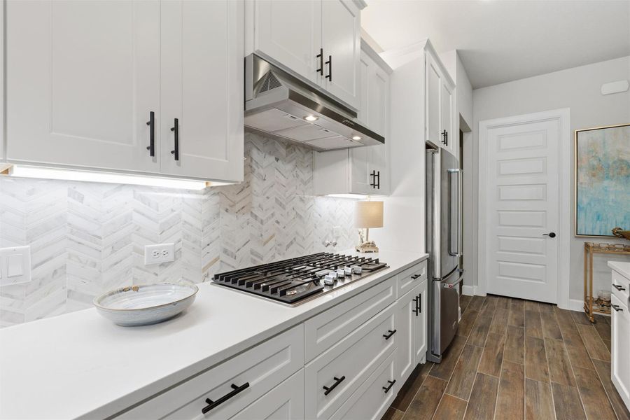 Chef's kitchen includes Whirpool stainless appliances, quartz counters and tile backsplash on the diagonal with under abd over-cabinet lighting. Chef's kitchen includes Whirpool stainless appliances, quartz counters and tile backsplash on the diagonal with under abd over-cabinet lighting.