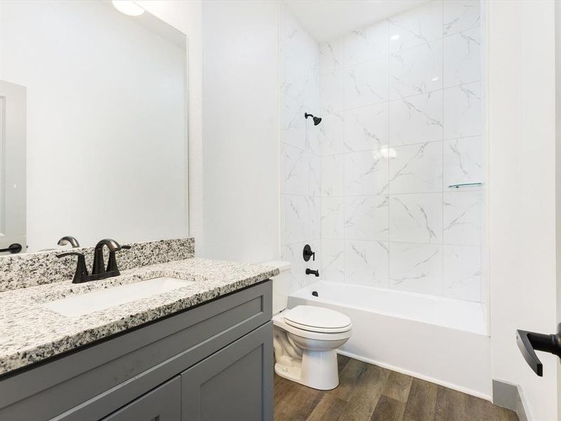 Bathroom with shower / washtub combination, vanity, and dark wood finished floors Bathroom with shower / washtub combination, vanity, and dark wood finished floors