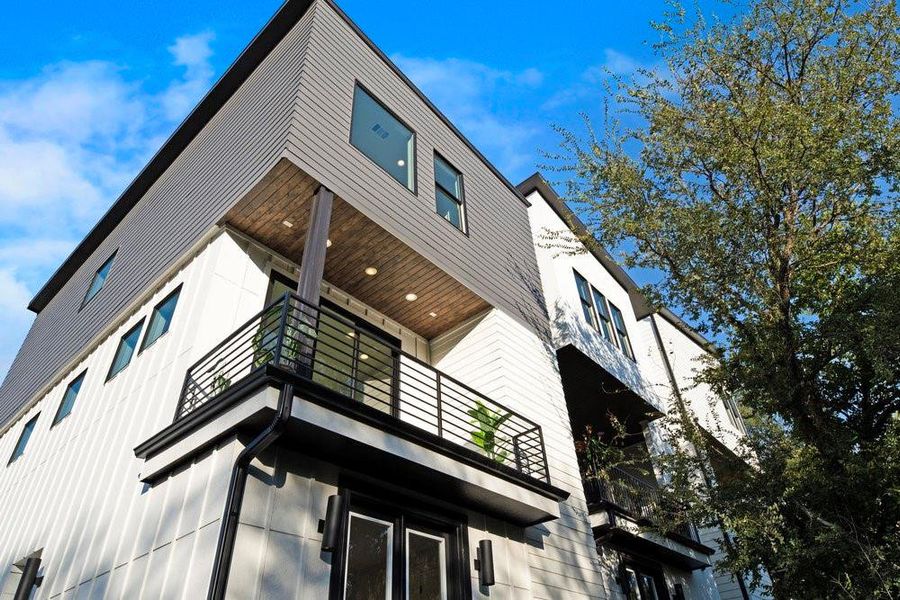 View of side of home featuring a balcony and board and batten siding
