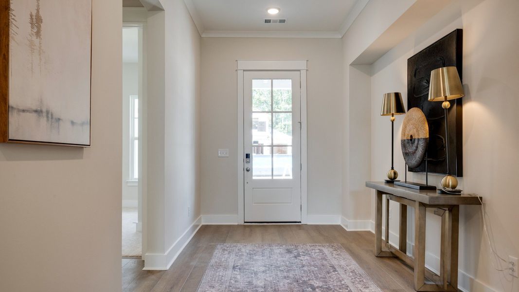 Front door leading into hallway with hardwood flooring