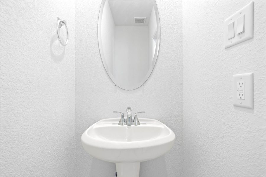 The powder room on the first floor includes a pedestal sink, mirror, and toilet to conveniently meet your needs. The powder room on the first floor includes a pedestal sink, mirror, and toilet to conveniently meet your needs.