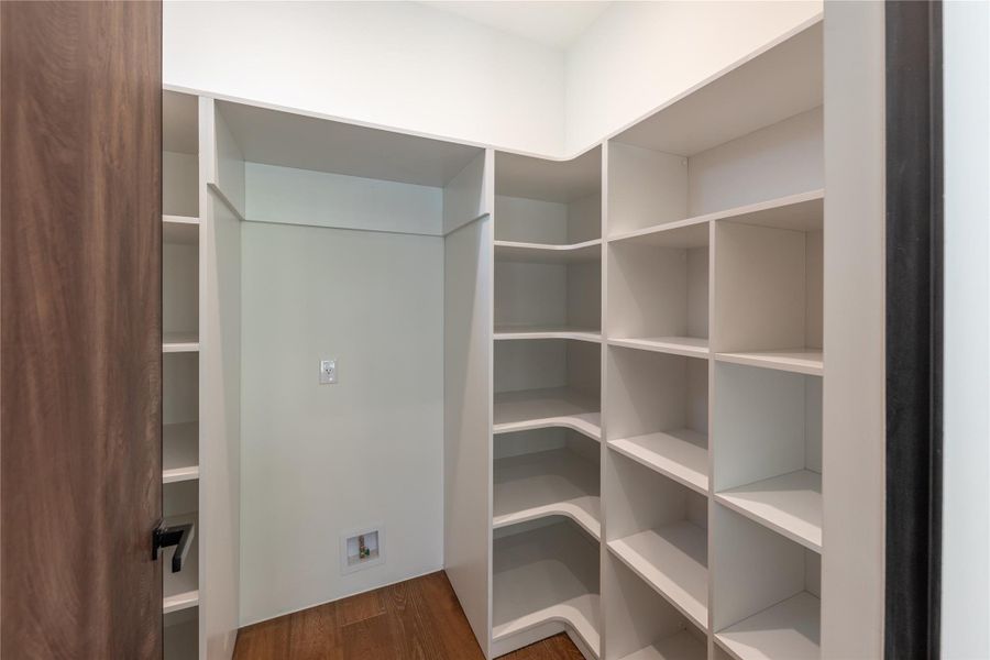 Organized living with built-in shelving and hardwood flooring in this versatile closet space.