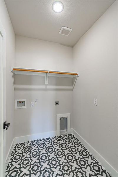 Clothes washing area with hookup for a gas dryer, washer hookup, hookup for an electric dryer, and a textured ceiling