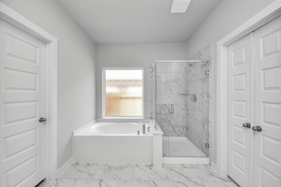 Delight in a spacious walk-in shower enveloped in stylish tile surround and unwind in a separate garden tub adorned with custom detailing. Delight in a spacious walk-in shower enveloped in stylish tile surround and unwind in a separate garden tub adorned with custom detailing.
