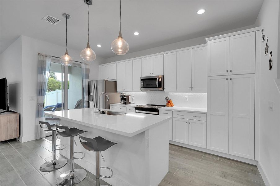 Beautifully appointed kitchen with quartz countertops and upscale lighting.