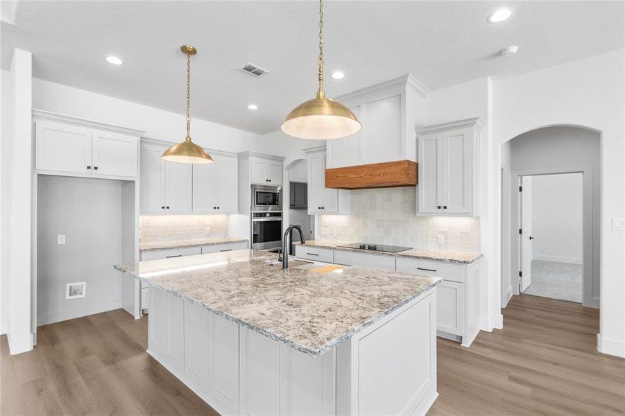 Stainless steel appliances, electric cooktop, and recessed lighting.