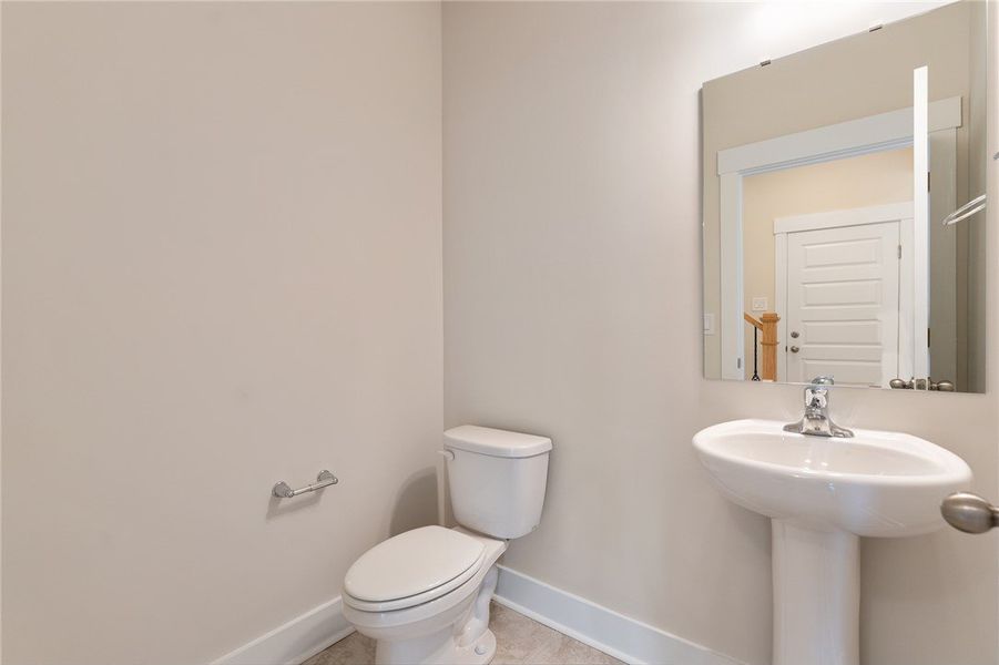 A well-appointed half bath features a pedestal sin