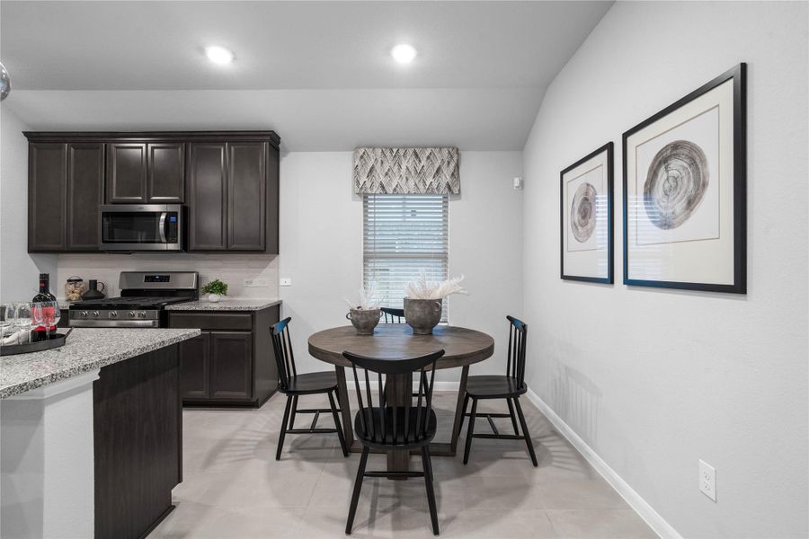 This dedicated dining area is a natural extension of the open-concept kitchen, offering a perfect spot for morning coffee or everyday meals, complemented by recessed lighting, window and tile flooring.