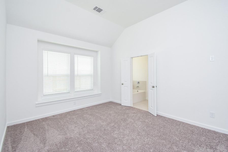 High ceiling, earth toned carpeting, double windows and wall and floor space, galore, fill your primary suite.