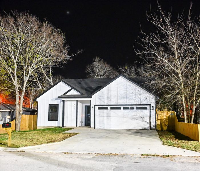 View of front of home with driveway, board and batten siding, and an attached garage