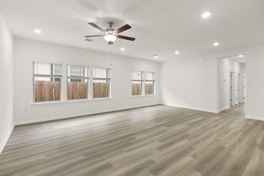 Spacious room featuring light-toned flooring, recessed lighting, and a ceiling fan