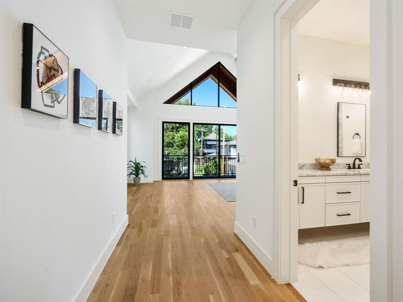 Hall with lofted ceiling and light wood-type flooring