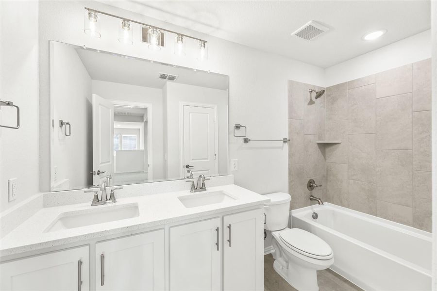 Bathroom with double sink vanity, white cabinets, and tiled shower-tub combo Bathroom with double sink vanity, white cabinets, and tiled shower-tub combo