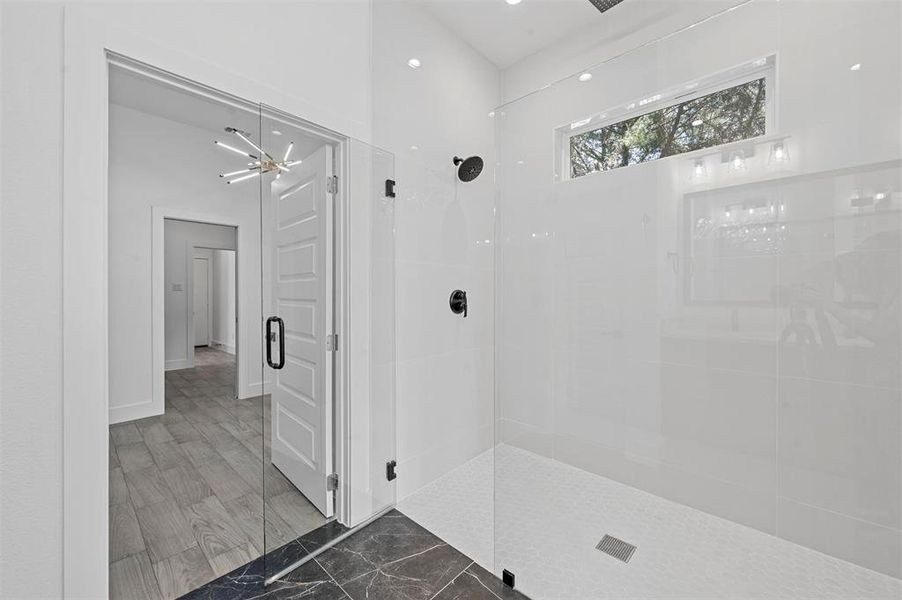 Bathroom featuring a shower with shower door and wood-type flooring