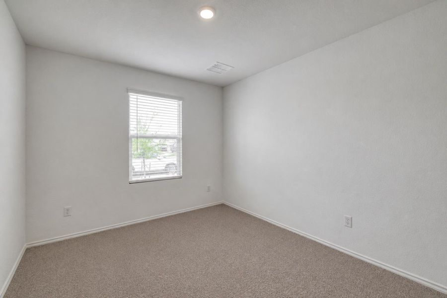 Bright room featuring neutral-toned carpet, white walls, and a single window with horizontal blinds Bright room featuring neutral-toned carpet, white walls, and a single window with horizontal blinds